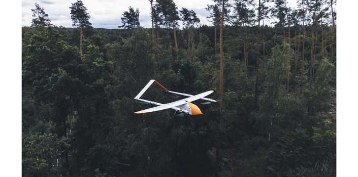White-orange Evolonic drone flies over forests to detect fires at an early stage